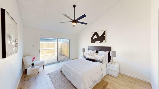 bedroom featuring baseboards, a ceiling fan, wood finished floors, access to exterior, and high vaulted ceiling