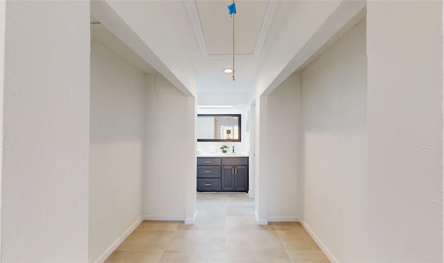 hallway with attic access, baseboards, and a sink