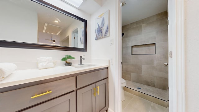 bathroom featuring tiled shower, vanity, toilet, and tile patterned floors