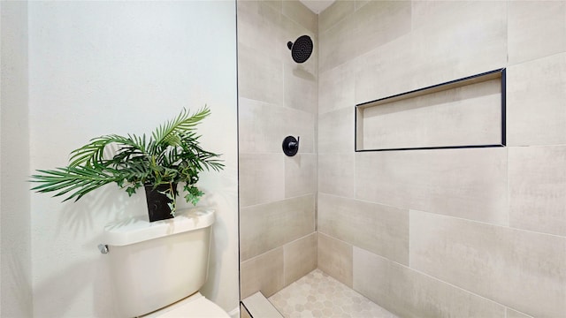 bathroom with toilet and tiled shower