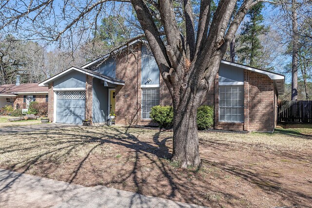 mid-century inspired home with an attached garage, driveway, fence, and brick siding