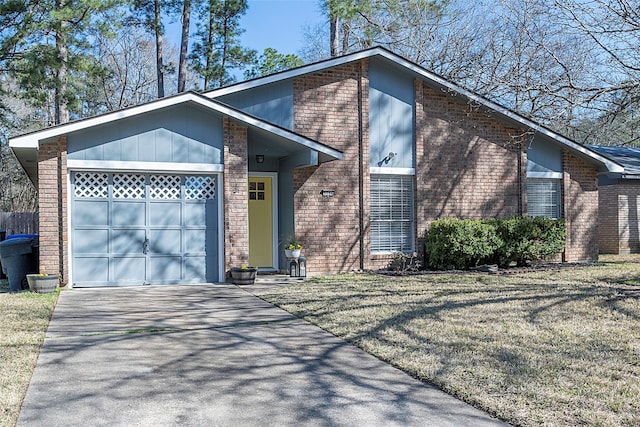 mid-century modern home with a garage, brick siding, a front lawn, and aphalt driveway