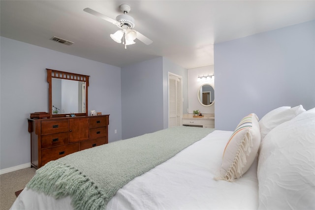 carpeted bedroom with ensuite bathroom, a ceiling fan, visible vents, baseboards, and a closet