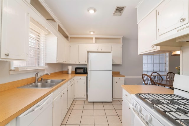 kitchen featuring light tile patterned floors, visible vents, white cabinetry, a sink, and white appliances