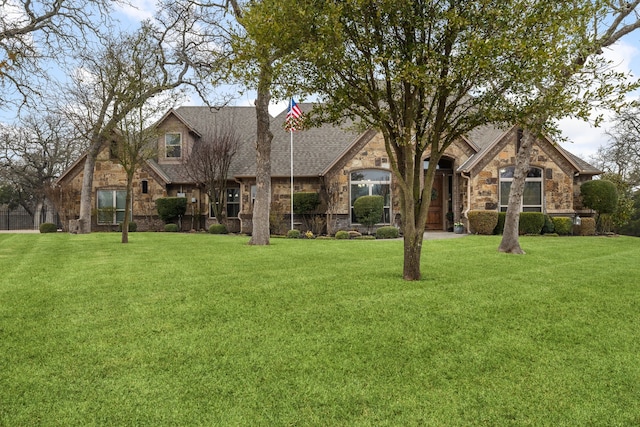 view of front of home featuring stone siding and a front yard