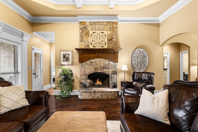 living room with a fireplace, ornamental molding, arched walkways, and wood finished floors