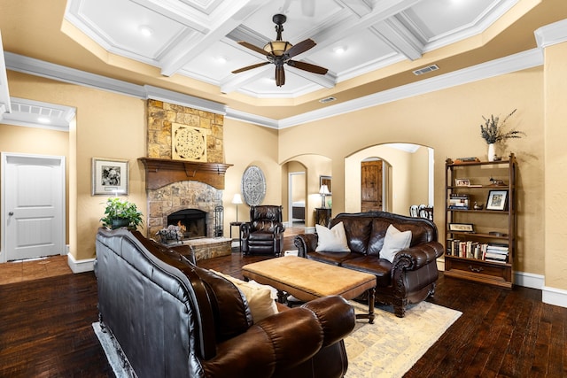 living room with arched walkways, a stone fireplace, coffered ceiling, beamed ceiling, and hardwood / wood-style flooring