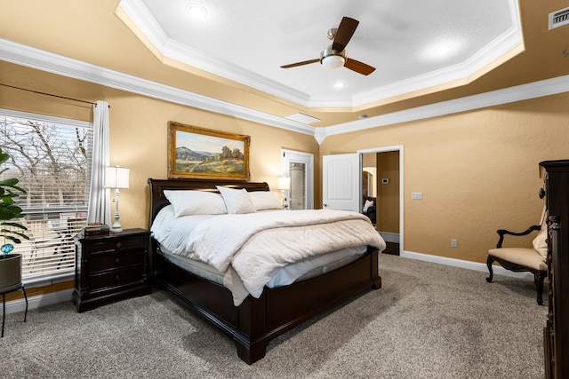 bedroom featuring baseboards, visible vents, ornamental molding, a tray ceiling, and carpet flooring