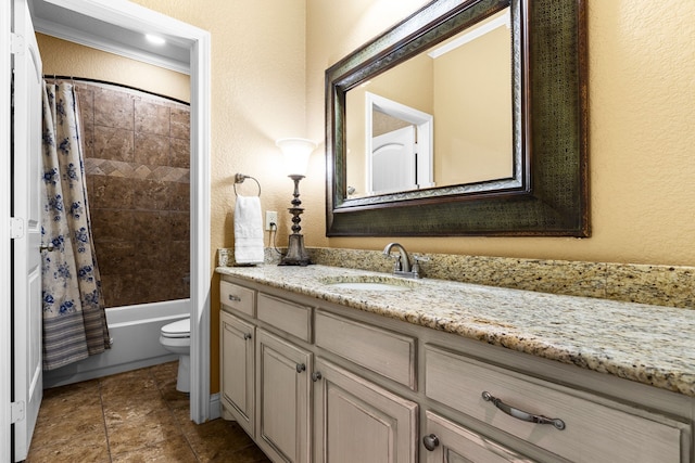 full bath featuring toilet, a textured wall, shower / bath combo, and vanity