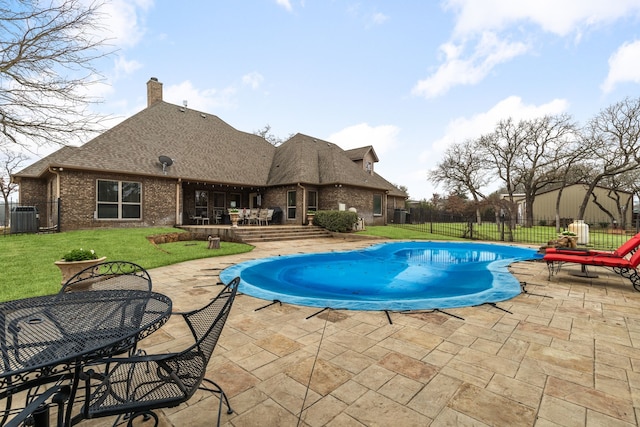 view of pool with central AC unit, a fenced in pool, a patio, fence, and a yard