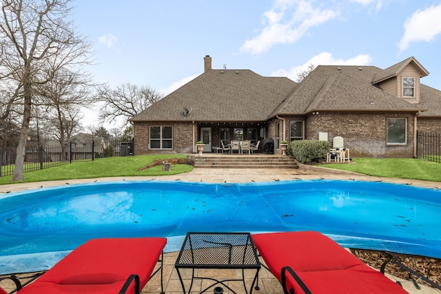 view of swimming pool featuring a patio, a yard, a fenced backyard, and a fenced in pool