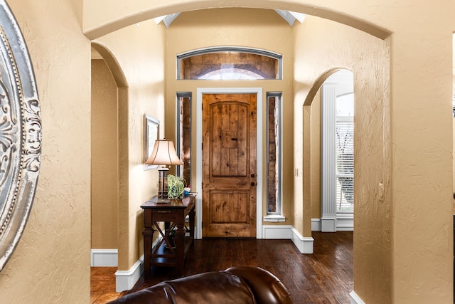 foyer entrance featuring hardwood / wood-style flooring, baseboards, and a textured wall