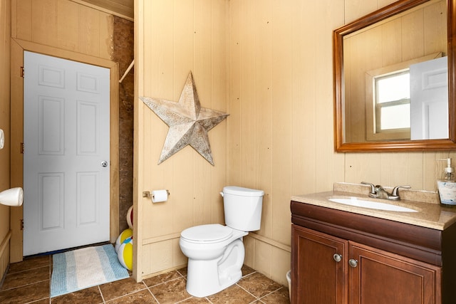 full bathroom with wood walls, vanity, and toilet