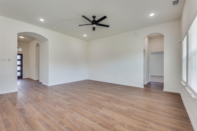 unfurnished room with arched walkways, ceiling fan, light wood-style flooring, recessed lighting, and visible vents