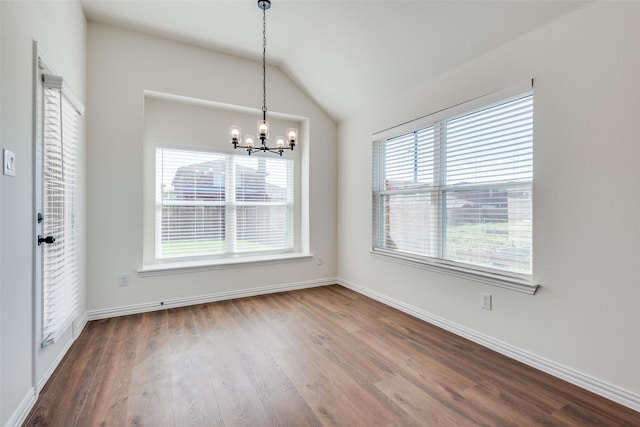 unfurnished dining area featuring vaulted ceiling, wood finished floors, and a wealth of natural light