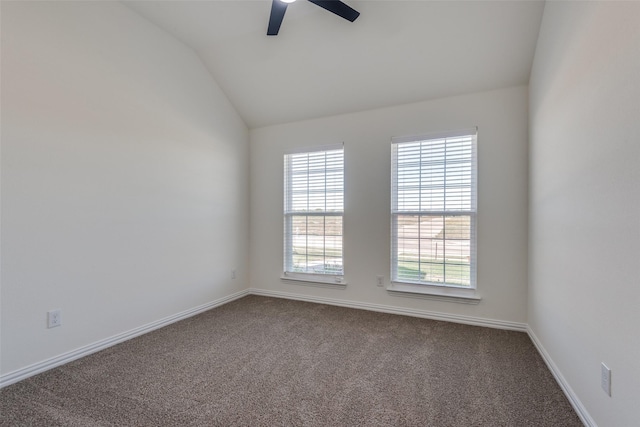 spare room featuring lofted ceiling, carpet floors, a ceiling fan, and baseboards