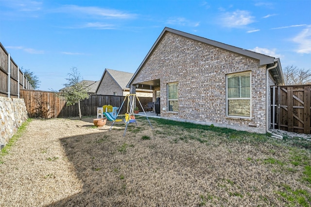 back of property with a lawn, a patio area, and a fenced backyard