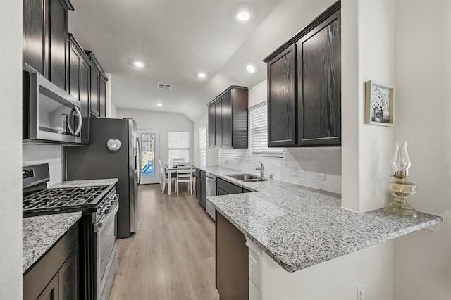 kitchen featuring light stone counters, a sink, visible vents, appliances with stainless steel finishes, and light wood finished floors