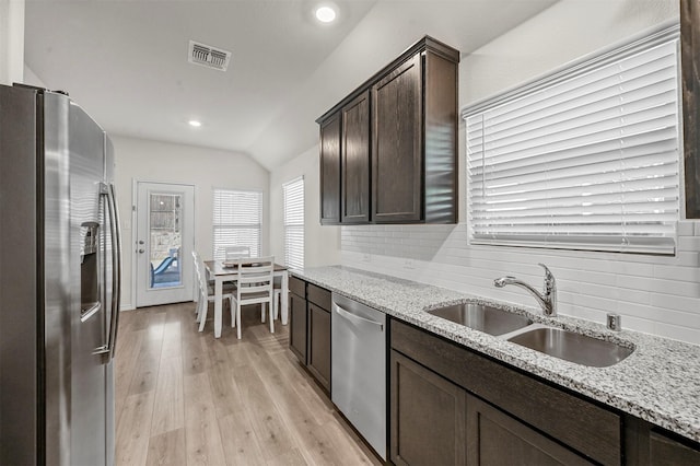 kitchen featuring visible vents, backsplash, appliances with stainless steel finishes, a sink, and dark brown cabinets