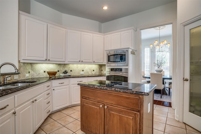 kitchen with light tile patterned floors, stainless steel appliances, a sink, and decorative backsplash