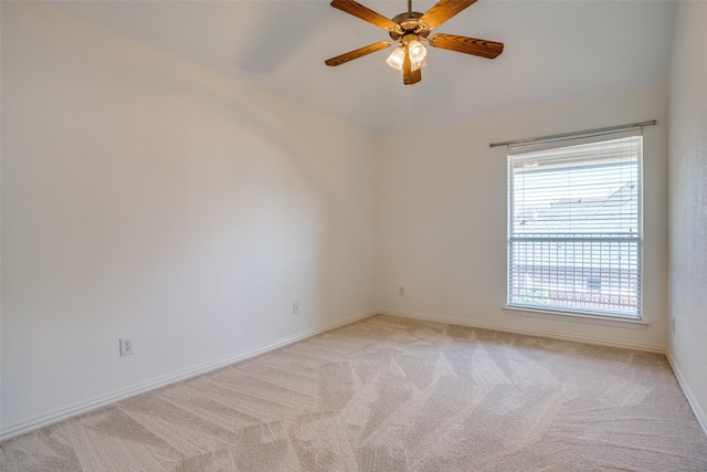 unfurnished room with light carpet, baseboards, and a ceiling fan