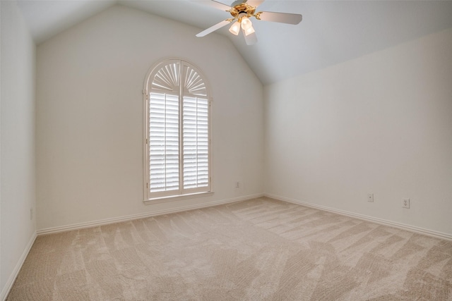 spare room featuring carpet floors, lofted ceiling, and a ceiling fan