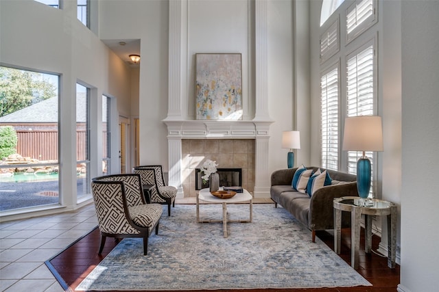 tiled living area featuring a tile fireplace and a high ceiling