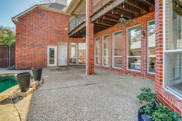 view of patio with ceiling fan, fence, and a fenced in pool