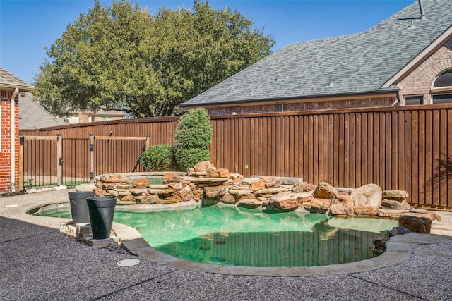 view of swimming pool featuring a jacuzzi, a fenced in pool, and a fenced backyard