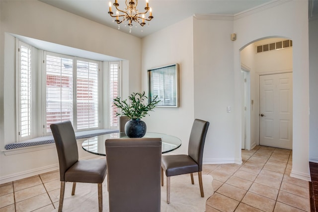 dining room featuring arched walkways, light tile patterned floors, a chandelier, visible vents, and baseboards