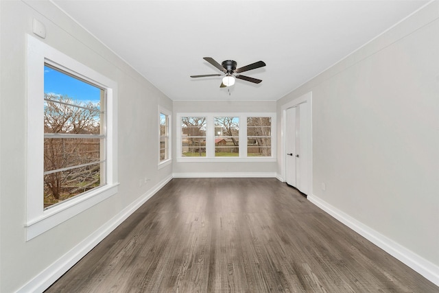 interior space featuring ceiling fan, baseboards, and dark wood-style flooring