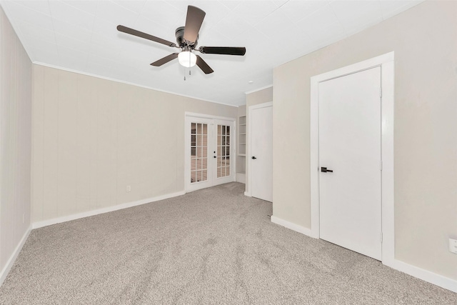 unfurnished bedroom featuring carpet floors, french doors, ornamental molding, a ceiling fan, and baseboards