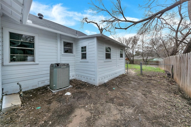 view of property exterior with central AC, a shingled roof, crawl space, and fence