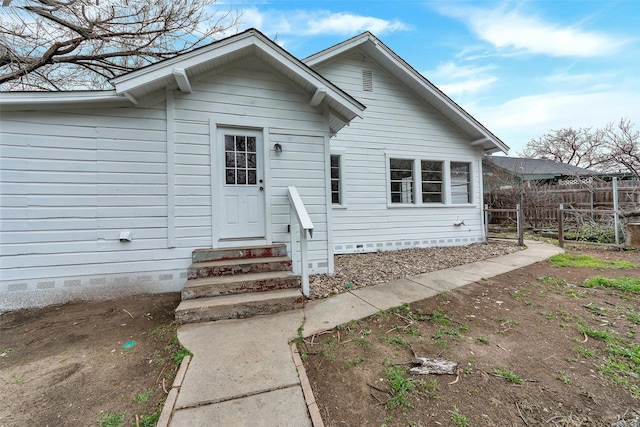 view of front of house featuring entry steps, crawl space, and fence