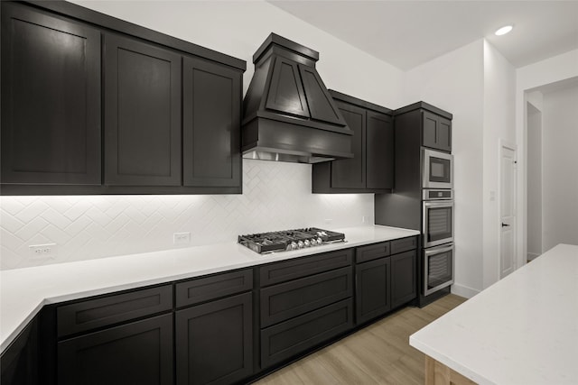 317 Willie Way, Burleson, TX 76028 - kitchen featuring stainless steel appliances, premium range hood, light wood-style floors, light countertops, and tasteful backsplash