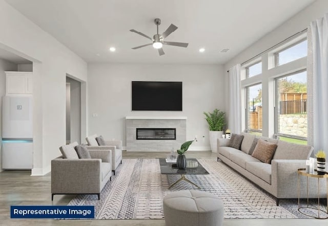 living room with recessed lighting, a glass covered fireplace, ceiling fan, and wood finished floors