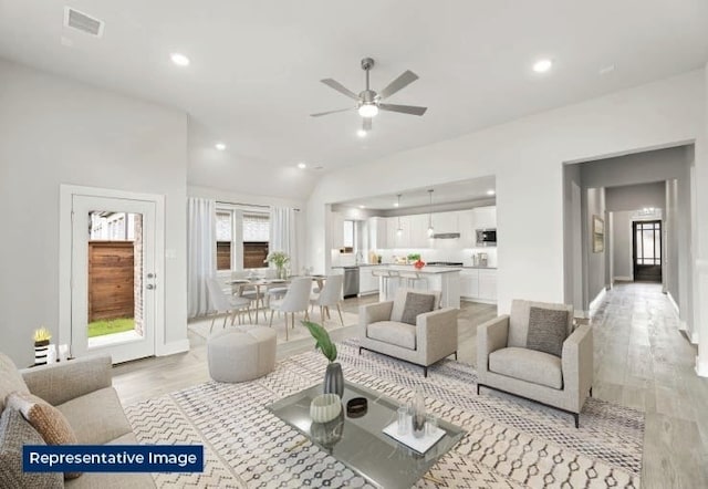 living room with visible vents, recessed lighting, a ceiling fan, light wood finished floors, and vaulted ceiling