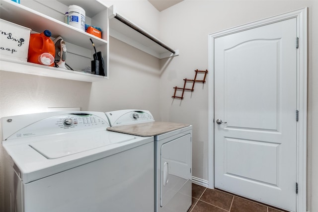 laundry room featuring laundry area, dark tile patterned floors, and washing machine and clothes dryer