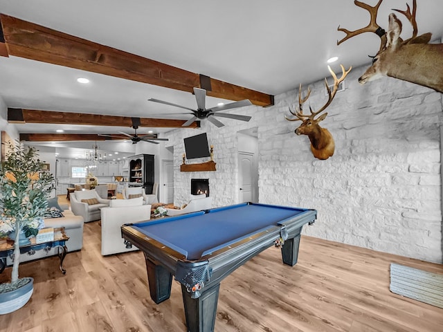 playroom featuring a fireplace, pool table, light wood-style flooring, ceiling fan, and beamed ceiling