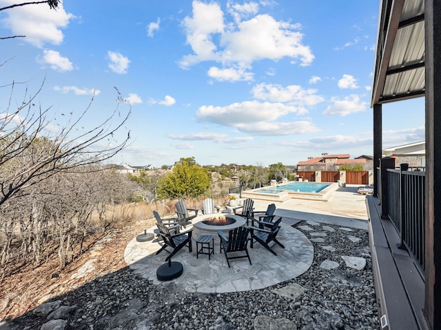 view of patio / terrace featuring a jacuzzi, an outdoor fire pit, fence, and a fenced in pool