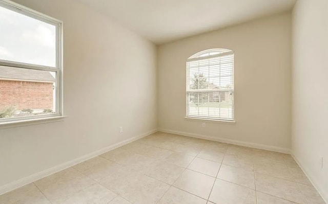 unfurnished room with light tile patterned floors and baseboards