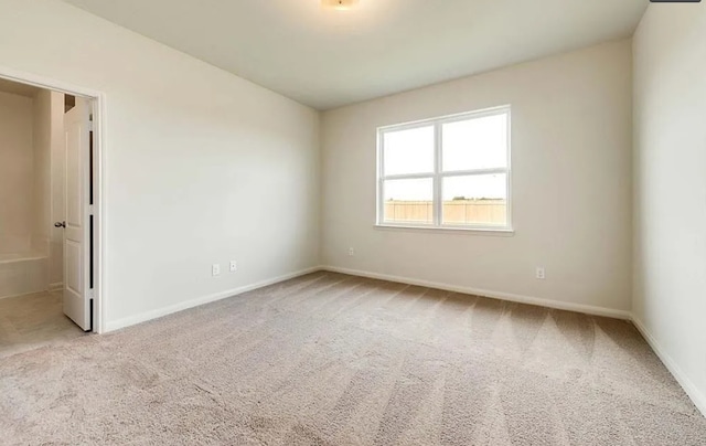 carpeted spare room with baseboards