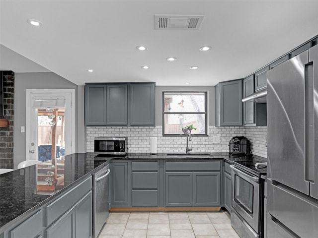 1709 Broadway St, Denton, TX 76201 - kitchen featuring dark stone counters, stainless steel appliances, a sink, gray cabinetry, and visible vents