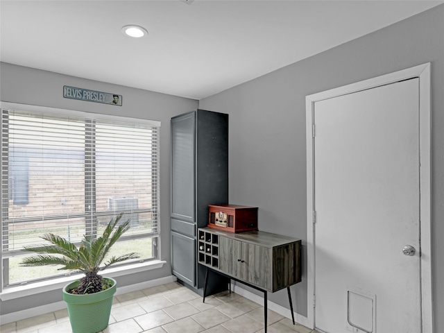 interior space featuring baseboards and light tile patterned flooring