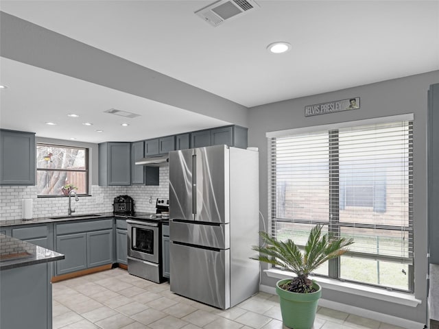 kitchen featuring gray cabinets, visible vents, appliances with stainless steel finishes, a sink, and under cabinet range hood