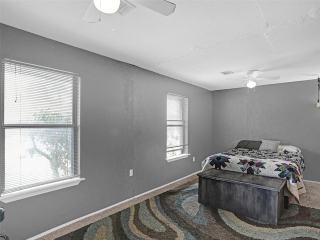 bedroom with carpet floors, multiple windows, ceiling fan, and baseboards