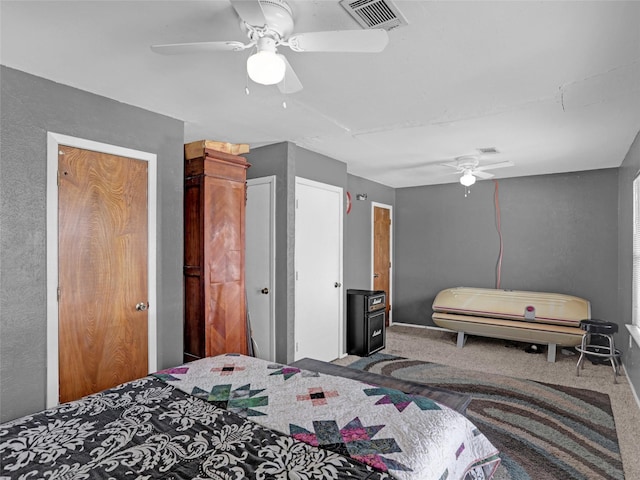 carpeted bedroom featuring a ceiling fan and visible vents