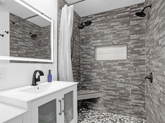 bathroom featuring tiled shower and vanity