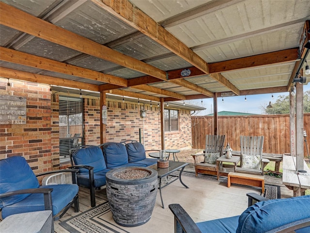 view of patio / terrace with an outdoor living space with a fire pit and fence