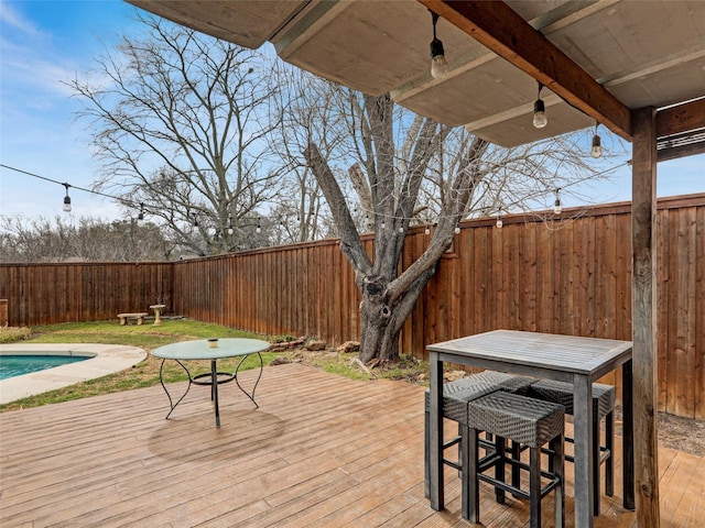 deck with outdoor dining area and a fenced backyard